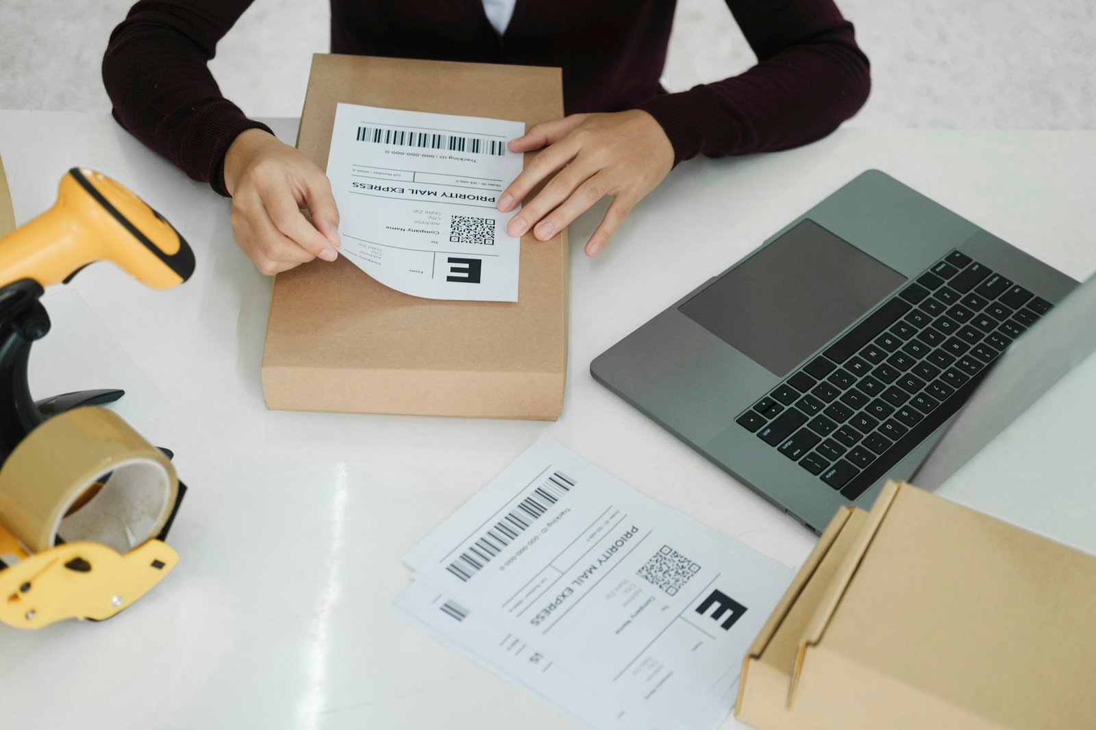 Young business owner putting shipping label on parcel.